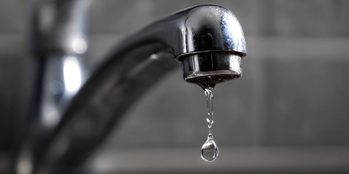 Low water pressure at a bathroom sink faucet with a slow drip, a common sign of plumbing issues such as leaks, clogged pipes, or valve problems in homes.