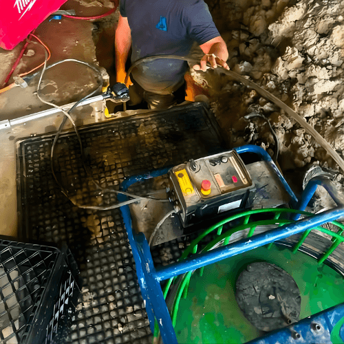 Technician conducting sewer line cleaning and inspection with professional equipment to clear blockages and restore flow.